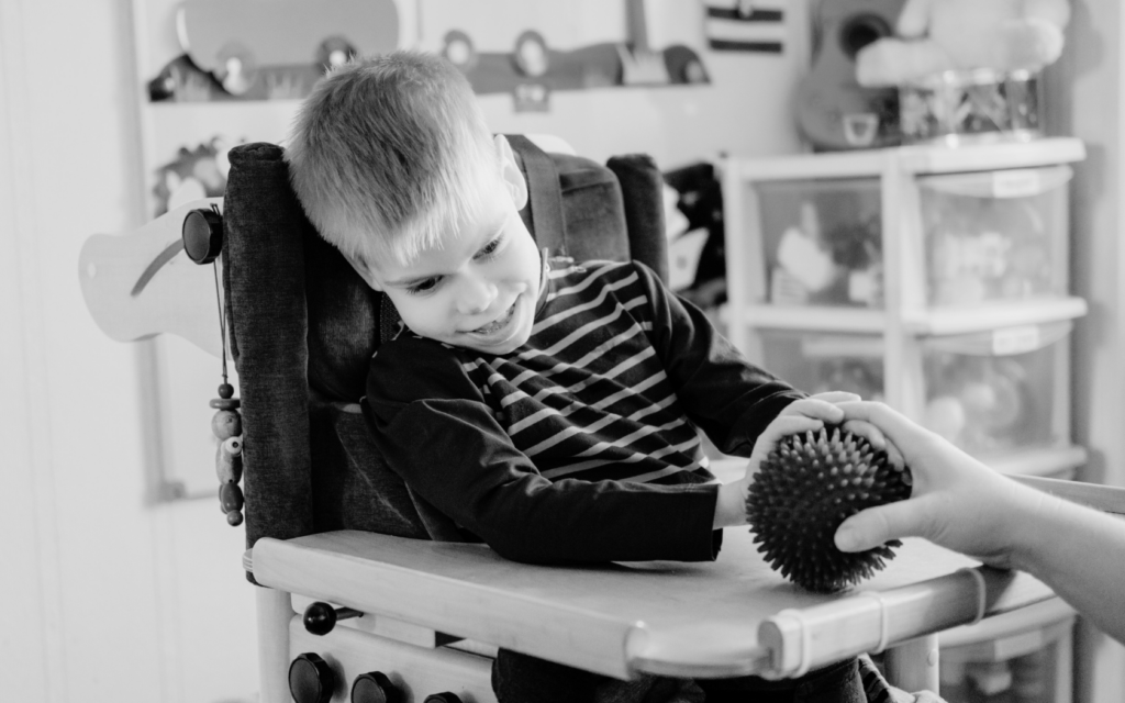 Little boy with spastic hemiplegia participates in physical therapy.