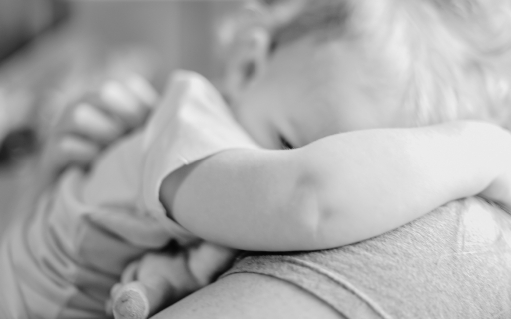 Parent lovingly holding toddler, providing comfort and support.





