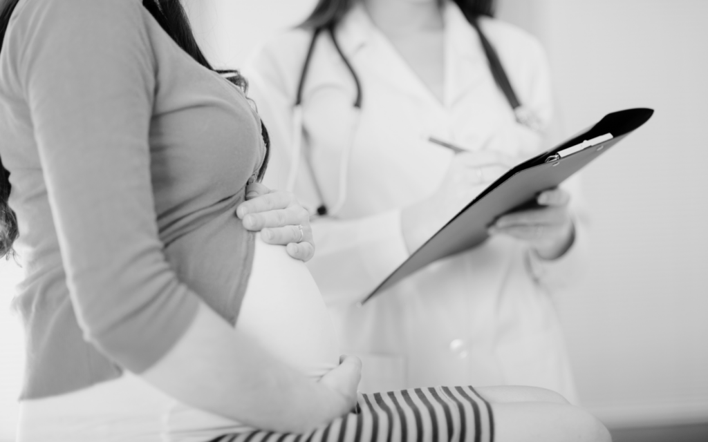 Doctor discusses test results with pregnant woman.