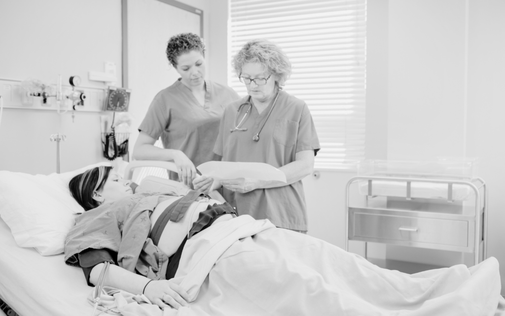 Doctor and nurse attending a pregnant woman in the labor and delivery room.